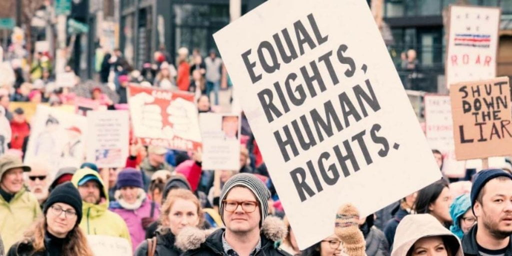 Women Holding a Chart Amoung People for Justice