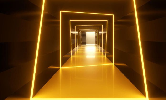 There are lights in the hall and is dark on the sides.