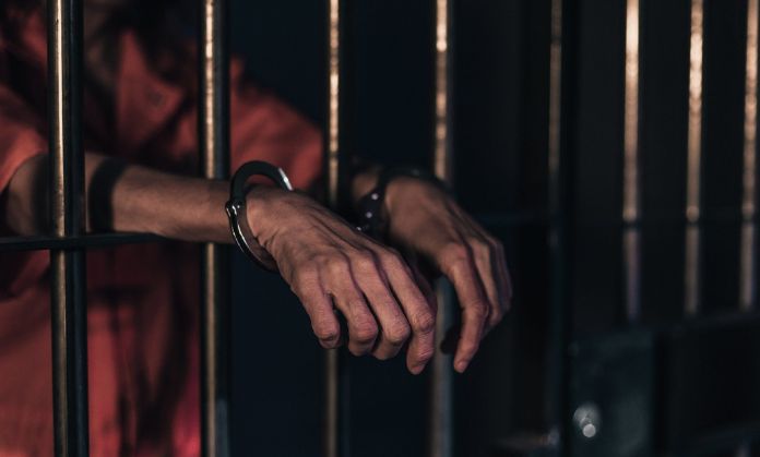 The prisoner put his hands out of the prison.