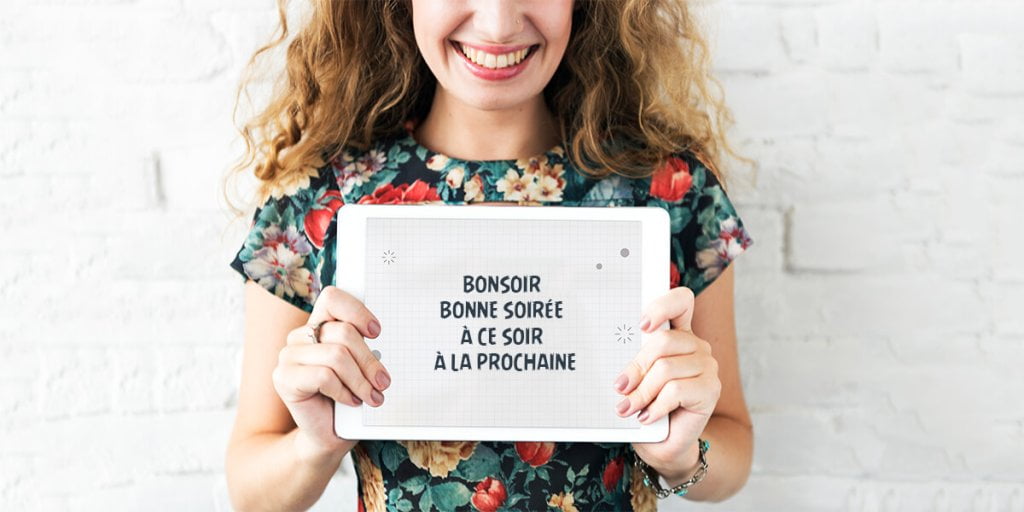 A French girl is holding a Tablet and showing Good Evening pharases