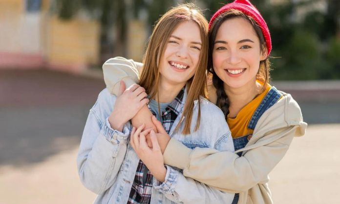 Friends are hugging and smiling.