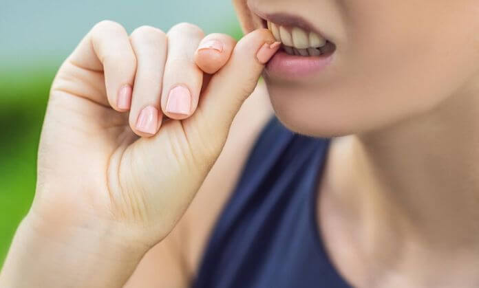 A girl bite the nails