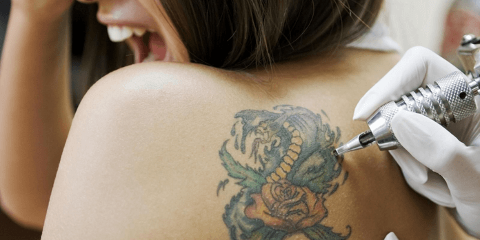 Tattoo artist make tattoo on girl shoulder