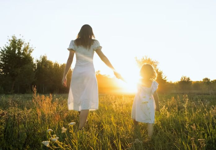 Mother and daughter walking in a field