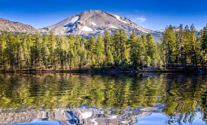 a mountain with trees and a lake 