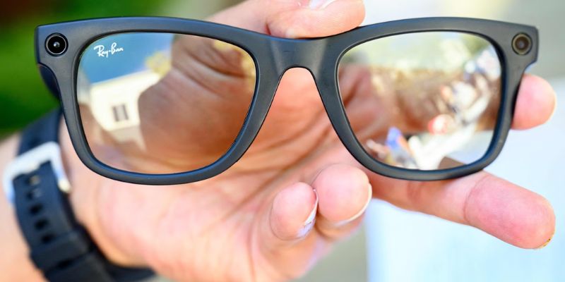 a person holding ray-ben glasses in their hand