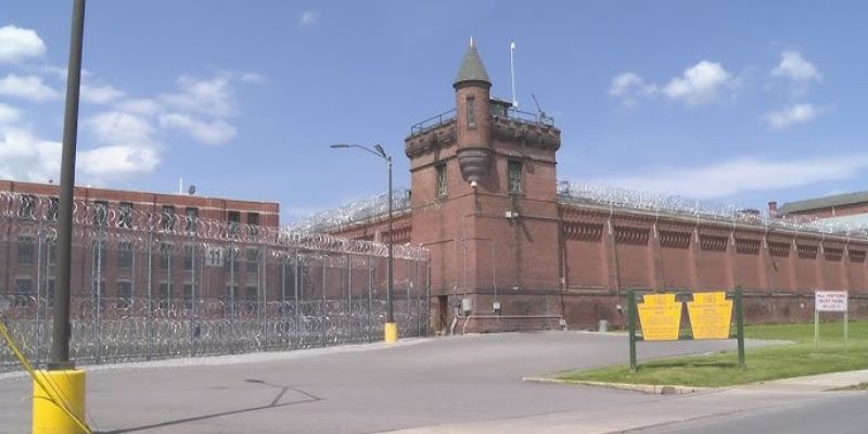 a brick building with a tower and barbed wire fence
