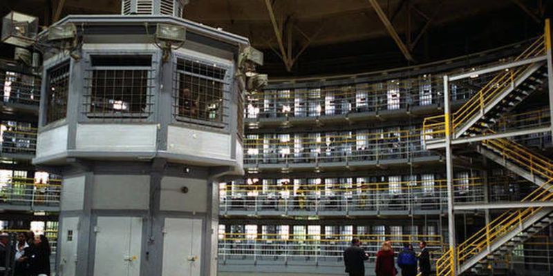 a prison cell with people standing in the middle 