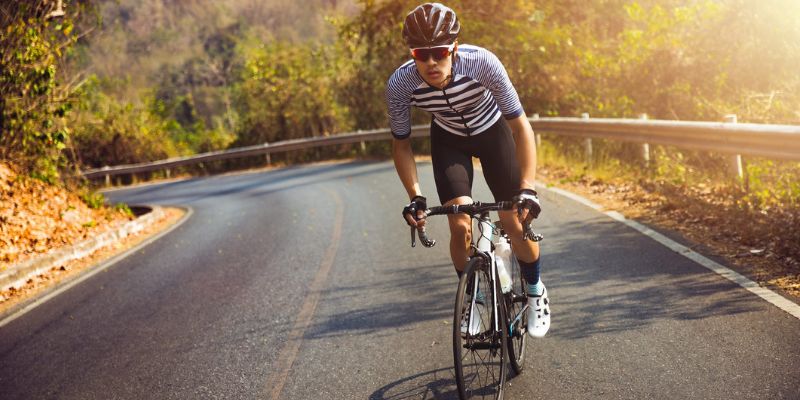 a person riding a bicycle on a road 