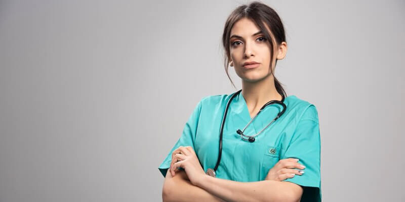 a person in a scrubs with her arms crossed 