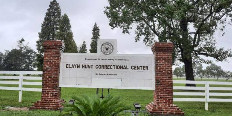 a sign in front of a brick post