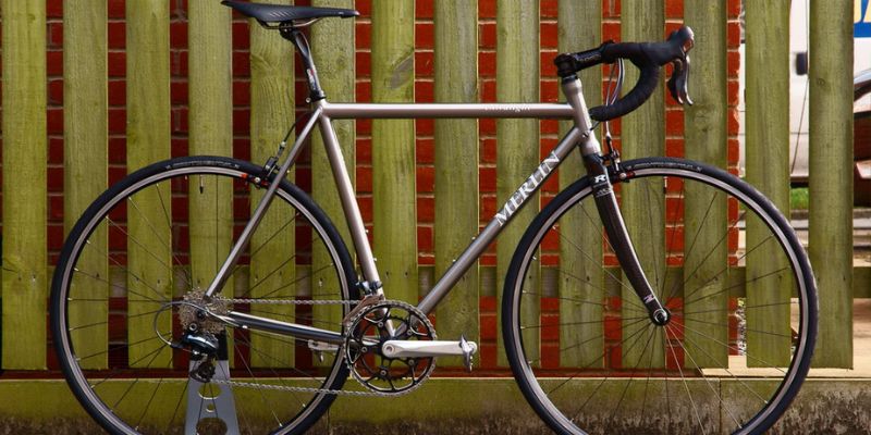 a bicycle leaning against a fence 