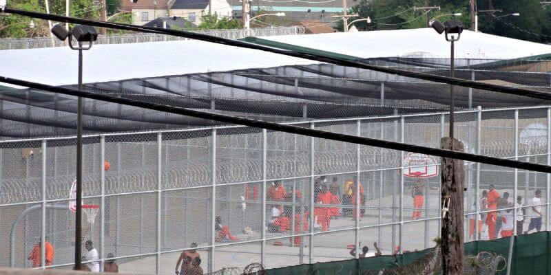 a group of people in orange uniforms in a prison