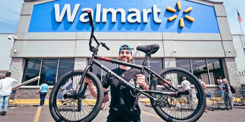 a person holding a bicycle in front of a walmart store 