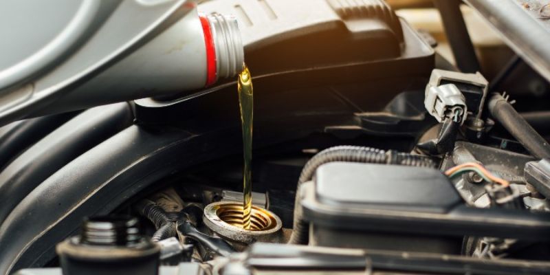 a pouring oil into a car engine 