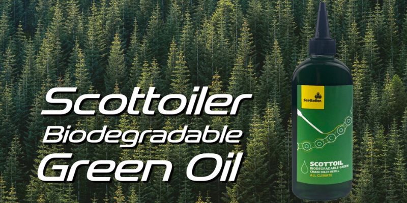 a bottle of green oil in front of a forest of trees 