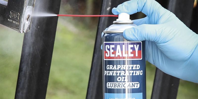 a person spraying oil on a window 