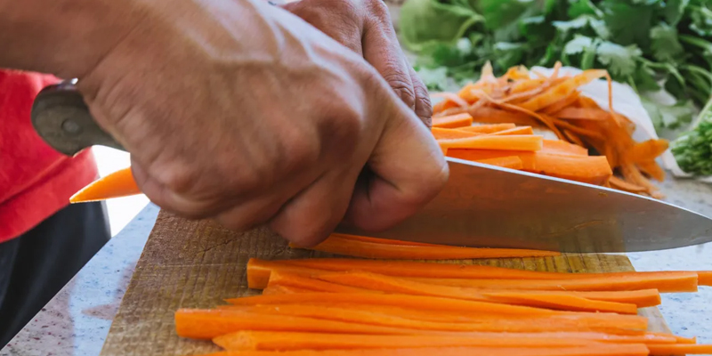 a person cutting carrots on a table 